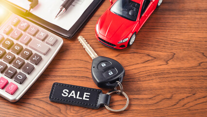 Keychain with word SALE on car key on table. Car sale and commercial concept. Car business or debt...