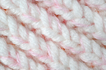 Pink, white wool knit background in close-up