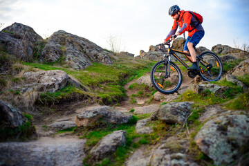 Fototapeta na wymiar Cyclist Riding the Mountain Bike on the Beautiful Spring Rocky Trail. Extreme Sport Concept