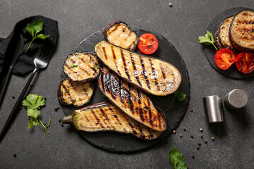 Composition with delicious grilled eggplants on dark background