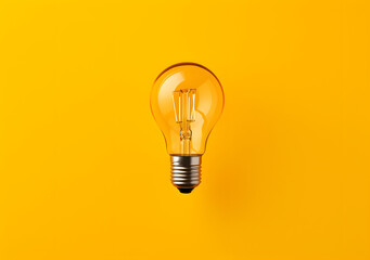 Transparent light bulb on the yellow wall
