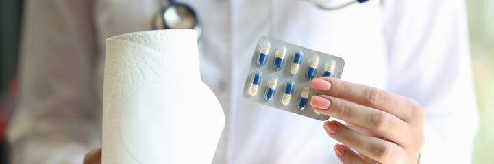 Female doctor holding blister of pills and toilet roll