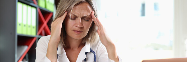 Frustrated doctor touching temples and closed eyes