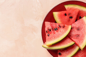 Plate with pieces of fresh watermelon on pink background