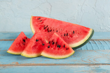 Fototapeta na wymiar Pieces of fresh watermelon on blue wooden table