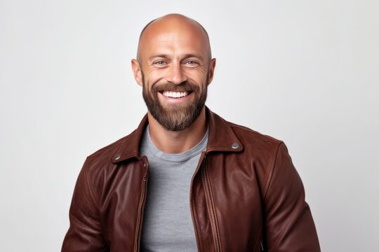 Portrait Of A Smiling Young Bald Man In A Brown Jacket On A White Background