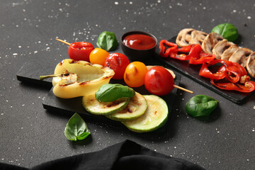 Boards with tasty grilled vegetables on grunge background
