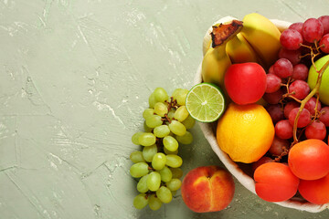 Wicker basket with different fresh fruits on grey background