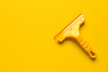 Plastic squeegee on orange background