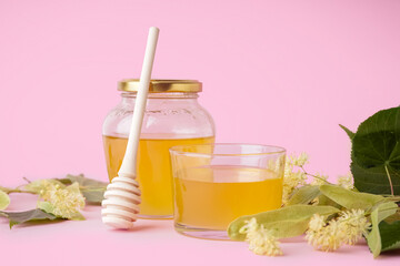 Glass bowl and jar with linden honey on pink background