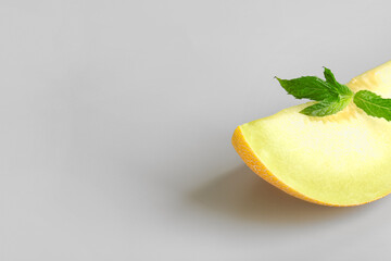 Fototapeta na wymiar Piece of sweet melon and mint on grey background