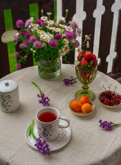 Morning tea with flowers and fruits on the terrace of a country house.