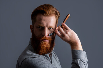 handsome hairdresser man with blade to make haircut. man in hairdresser studio.