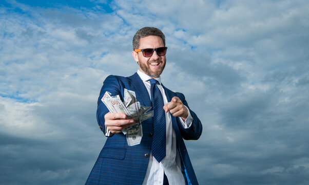 rich millionaire man with money pointing finger on sky background. rich millionaire man