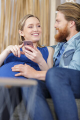 husband and pregnant wife taking a photo