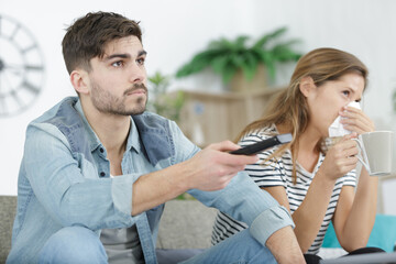 bored caouple on a couch watching tv