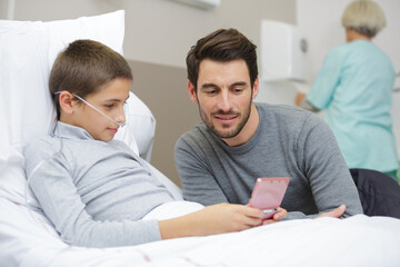 Fototapeta premium portrait of little son with father in hospital chamber