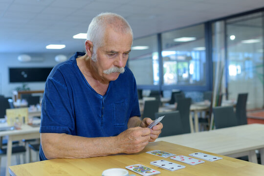 An Elderly Man Playing Cards