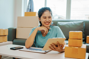 Fototapeta na wymiar Asian woman holding SME package box and hands using smartphone to receive online email order, chat box message, SME sellers, concept, e-commerce team, online sales.
