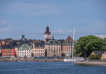 Obraz premium The old town Gamla Stan apartment and churches, pier with boats, a sunny summer morning in Stockholm