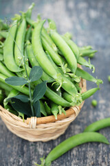 peas in a wicker basket on a rustic background