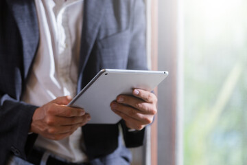 Close up selective focus at tablet in hand of businessman at table office.