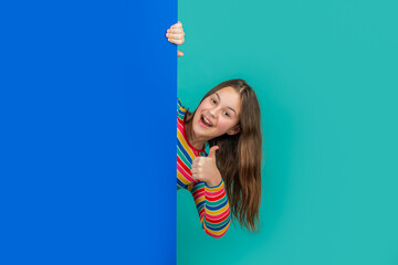amazed girl behind blank blue paper with copy space for advertisement