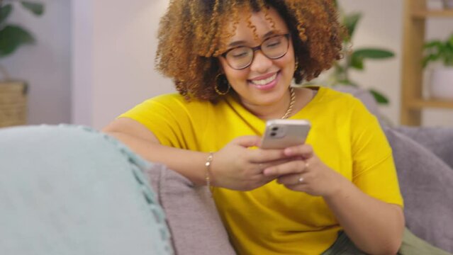 Texting, phone and woman on a sofa laughing at social media, joke or meme while chatting in her home. Smartphone, app and female person relax with silly, funny or online comic or text in living room