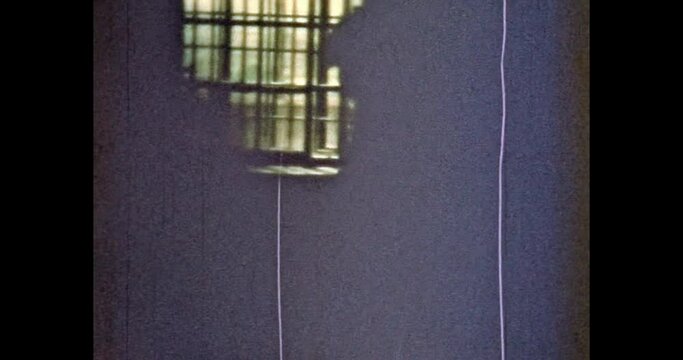 Woman silhouette in prison cell background of window bars. Concept of prisoner, penitentiary. Punishment for criminal in jail cage. Dark inside. Crime person print. Vintage film archive. Retro video