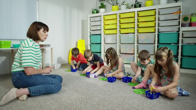 children in developmental classes in preschool. The teacher tells the lesson for playing at school in class. Education of children. High quality 4k footage. 