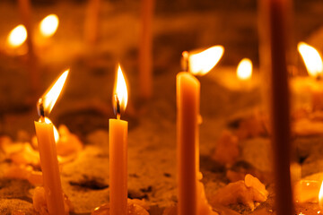 Burning candles in the church on a dark background. The idea of prayer and religion