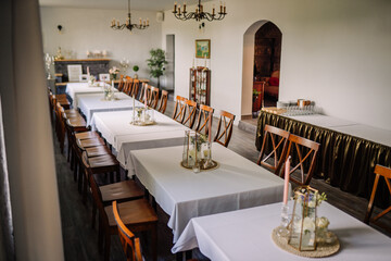 tables with white tablecloths are prepared for the celebration