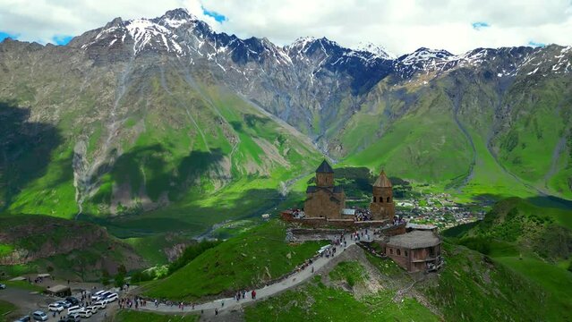 Trinity monastery on the green mountain Kazbek, view from a flying drone - stock video georgia