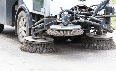 The machine washes and vacuums the sidewalks in the park