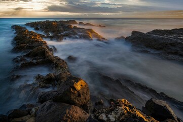 Obraz premium Scenic shot of a rocky beach at Snapper Rocks in Gold Coast, Queensland, Australia during sunrise