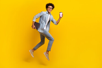 Full body profile photo of crazy guy jump run hurry hold netbook coffee isolated on yellow color background