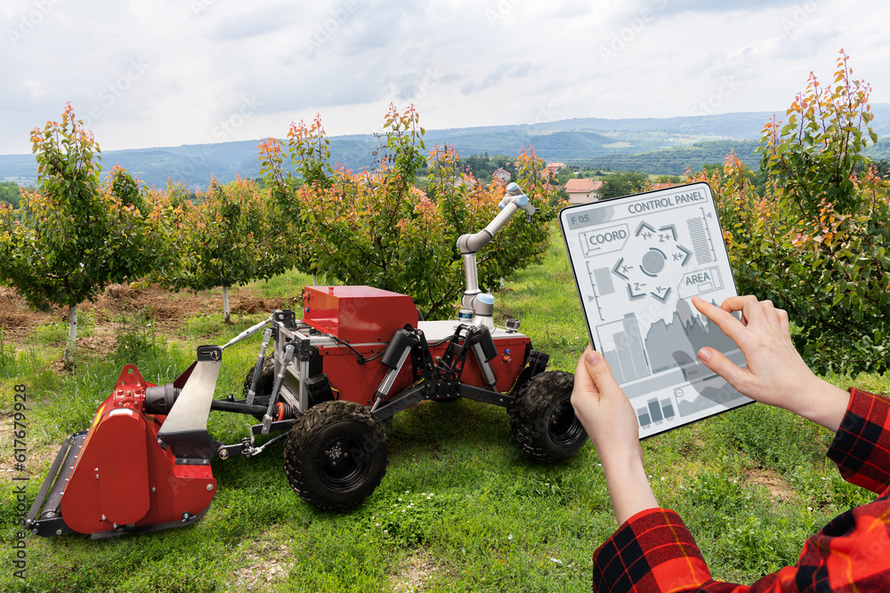 Poster farmer controls autonomous robot in a fruit garden. smart farming concept.