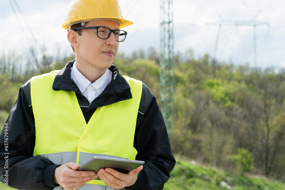 Poster Engineer with digital tablet on a background of power line tower..