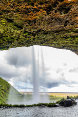 Passage under waterfall. Southern Iceland. Long exposure motion blurred water