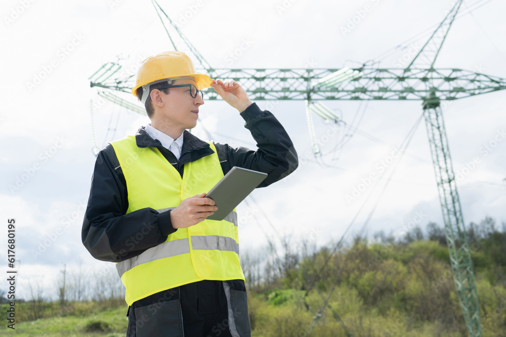 Aufkleber Engineer with digital tablet on a background of power line tower.
