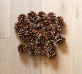 pine cones grouped on light oak wooden background, flat lay - 617680522