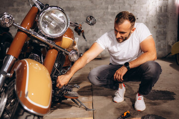 a man is repairing his retro motorcycle in the garage