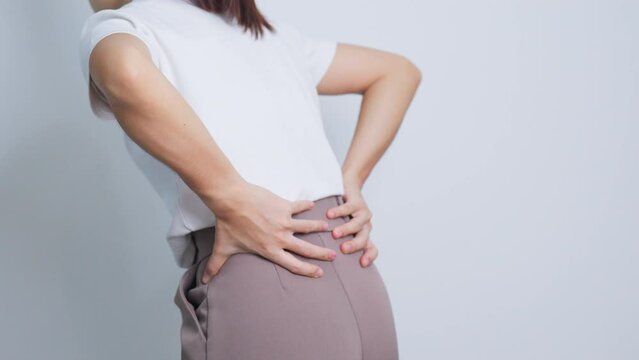 adult female with muscle pain on gray background. Elderly woman having back body ache due to Piriformis Syndrome, Low Back Pain and Spinal Compression. Office syndrome and medical concept