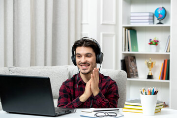 student online cute guy in checked shirt with glasses studying on computer clapping hands