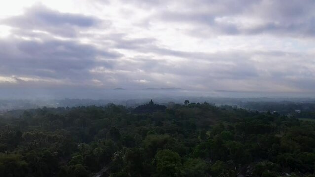 Borobudur Temple in the middle of forest. Cloudy morning sky. Indonesian heritage. Wonders of the World