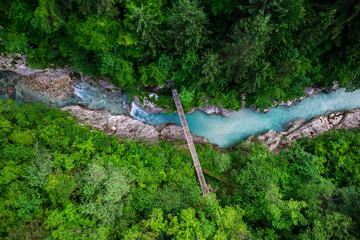 Soca river in Slovenia. Aerial drone top down view of emerald green river in forest