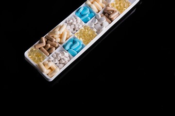Obraz na płótnie Canvas Box with different pills on a black background