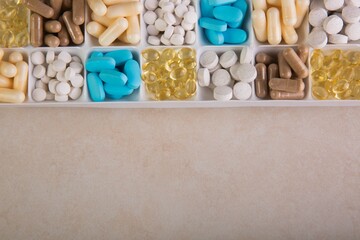 Box with different pills on a brown background