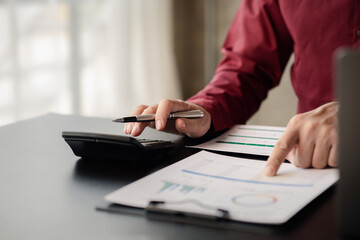 Business man pointing to a pie chart document showing company financial information, He sits in her private office, a document showing company financial information in chart form. Financial concepts.