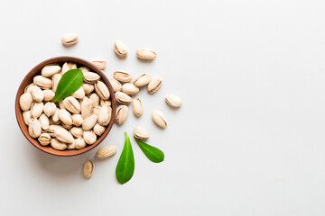 Fresh healthy Pistachios in bowl on colored table background. Top view Healthy eating concept. Super foods